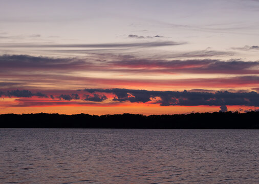 red and pink dawn colors over lake