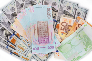 Ukrainian hryvnia money lies on euro bills and US dollars, top view, the concept of supporting the Ukrainian economy from the side of the European Union and the USA