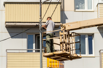 a man fixes electrical wiring on a lamppost