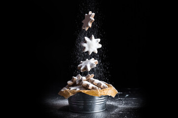 christmas cinnamon star cookies falling in the air with powdered sugar 