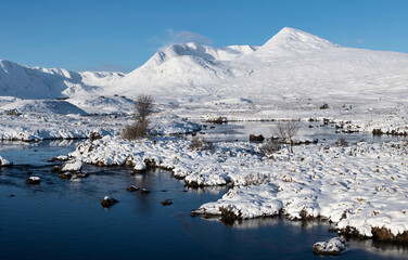 Fototapeta na wymiar Beautiful Winter landscape image looking towards Scottish Highlands mountain range across Loch Ba on Rannoch Moor