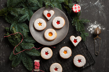 Linzer cookies served on a plate decorated with spruce branches
