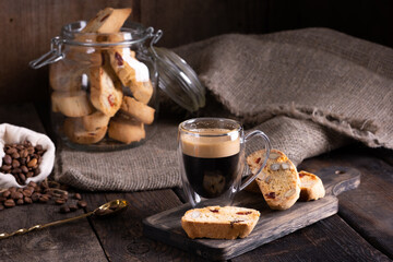 Traditional Italian almond biscuits biscotti served on a wooden board with a cup of aromatic coffee