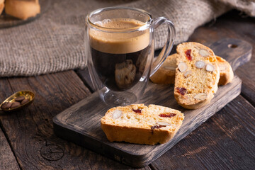 Traditional Italian almond biscuits biscotti served on a wooden board with a cup of aromatic coffee
