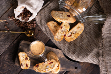 Traditional Italian almond biscuits biscotti served on a wooden board with a cup of aromatic coffee