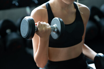 Beautiful Caucasian woman wearing workout clothes Use your arms to lift small dumbbells in the gym. Fat Burning Motivation to have a good body shape. concept sustainable life