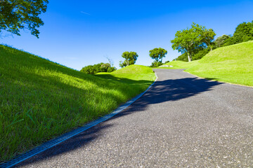 青空のゴルフ場・コブに囲まれた上り坂の空へと続くカート道・一本道（千葉県木更津市）