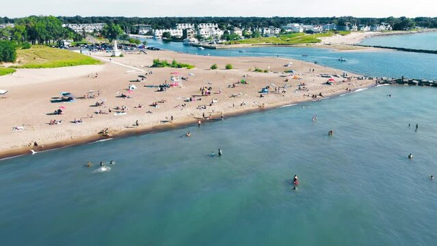 Aerial Flying over New Buffalo Beach. A large sandy beach and many people relaxing near Lake Michigan.