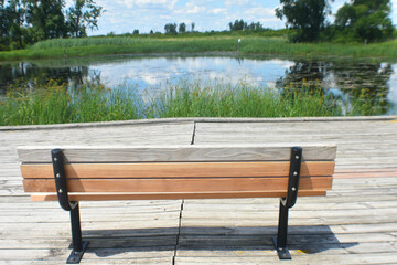 Wooden Sitting Bench overlooking pond in Prairie 