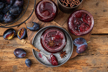Homemade plum jam in a glass jar on a wooden background.Selective focus