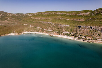 drone photo with sunny beach with people and a big blue ocean and clear sky. A perfect nature holiday day at the sea with boats and trees