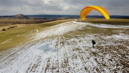 BYKOVICE Czech republic - MARCH 23, 2022: paragliding flying and ground handling training on Bykovice meadow,aerial panorama view shot with drone DJI.