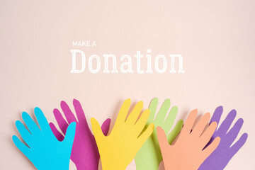 Donation and charity creative background with colorful paper hands. Top view, flat lay