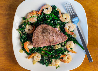 season tuna steak  with spinach onions and shrimp