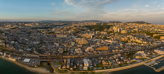Obraz premium Panoramic aerial view of train line cutting through sprawling coastal town