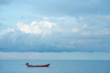 A small fishing boat floating in the blue sea.