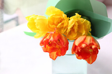 bouquet of yellow and red tulips in front of spring scene