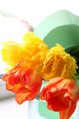 bouquet of yellow and red tulips in front of spring scene