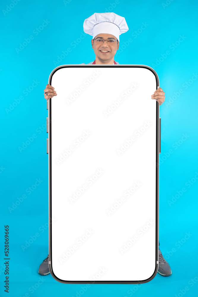 Aufkleber man chef with phone. cellphone with white screen. mock up phone in hand chef restaurant. guy with bi