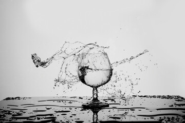 Glass with splashes of water with reflection 