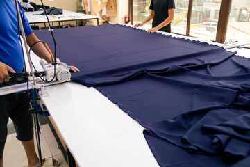 Person cutting fabric with machine