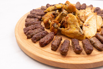 Grilled meat barbecue served on the wooden round board
