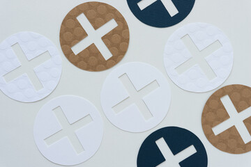 blue and brown x, plus, positive, cross symbols on blank paper