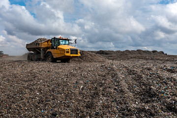 Obraz premium Dumper truck unloading on landfill site