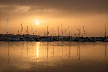 Fototapeta na wymiar Small harbor with yachts and sail boats in at sunset