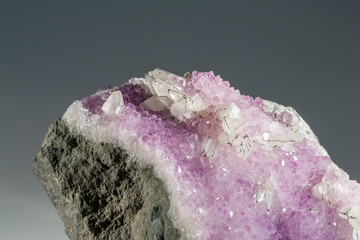 A sample of a natural mineral Amethyst (oxide sclass) a brush of crystals with calcite and pyrite on the ribs of the crystals. Museum Mineral Series. Mineralogical sample