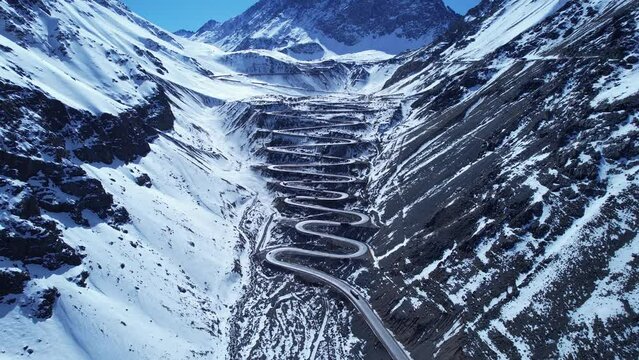 Highway road with scenic curves winding road at Andes Mountains. Los Caracoles highway road near Santiago Chile. Snowing scenery. Snowing road. Curves background. Curves road.
