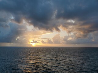 Obraz na płótnie Canvas Sunset over Ocean Water Clouds