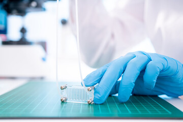 Organ-on-a-chip (OOC) - microfluidic device chip that simulates biological organs that is type of artificial organ. Prototype of design lab-on-a-chip in microfluidic laboratory