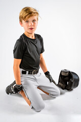 Young male baseball player sitting on his knees