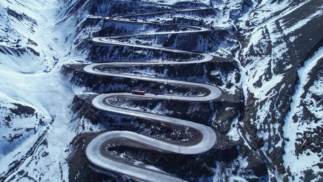 Famous winding road at Andes Mountains. Los Caracoles highway road near Santiago Chile. Snowing scenery. Snow highway road. Winding curves background near Argentina and Chile border.