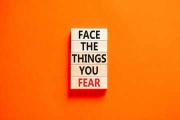 Face the things you fear symbol. Concept words Face the things you fear on wooden blocks on a beautiful orange table orange background. Business and face the things you fear concept. Copy space.