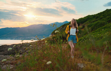 Woman tourist with backpack walking in mountains.
