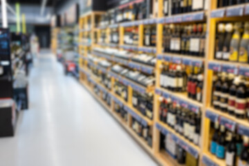 Out of focus photo of wine bottle shelves in store