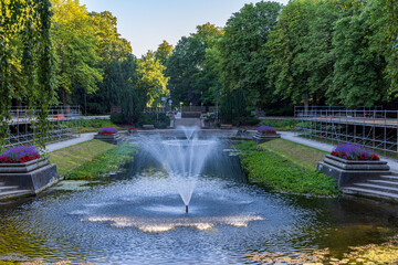 Fountains and large classic pond surrounded with flowers in public park Noorderplantsoen in...