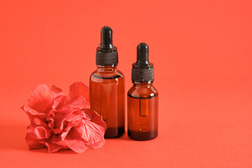 two amber glass dropper bottles and hibiscus flower © Natasha