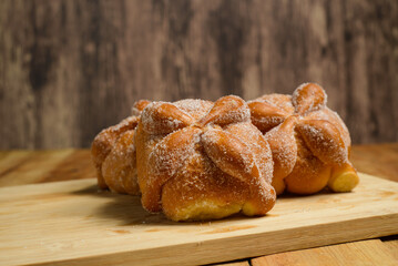 Pan de muertos on a wooden table. Typical Mexican dessert for the Day of the Dead. 