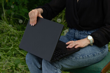 woman opens laptop, work online, outdoors, business woman