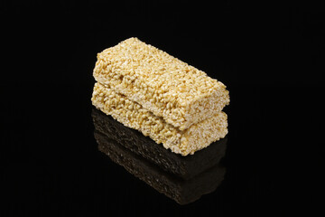 Sesame gozinak on a black table with reflection. Close-up