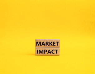 Market impact. Concept word Market impact on wooden cubes. Beautiful yellow background. Business and Market impact concept. Copy space.