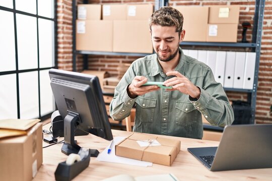 Young man ecommerce business worker make photo to package at office
