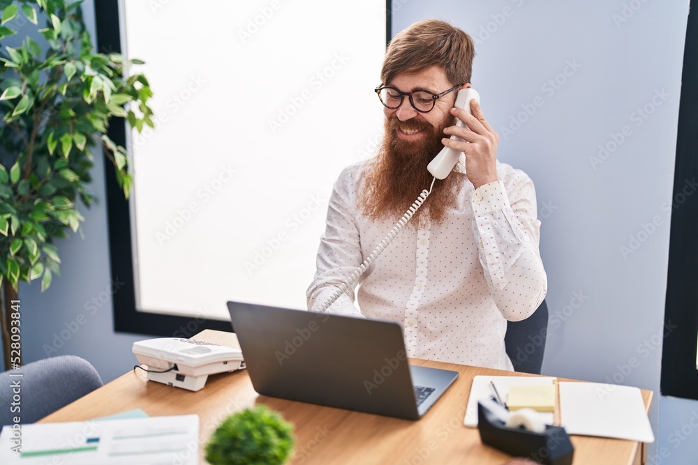 Sticker young redhead man business worker using laptop talking on smartphone at office