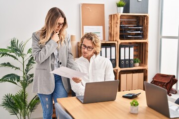 Man and woman business workers using laptop working at office