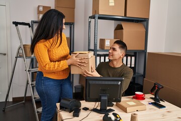 Man and woman ecommerce business workers holding packages at ecommerce office