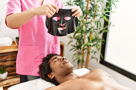 Young african american man having skin face treatment at beauty center