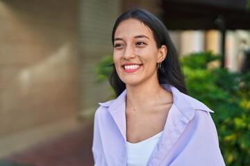 Young beautiful hispanic woman smiling confident looking to the side at street